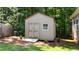 Storage shed with double doors and window in wooded back yard at 149 Hadley Ln, Clayton, NC 27527