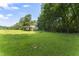 Spacious backyard with lush green grass and mature trees providing ample shade at 150 Williamston Ridge Dr, Youngsville, NC 27596
