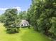 Exterior shot of a home featuring large, mature trees and a spacious grassy yard on a sunny day at 150 Williamston Ridge Dr, Youngsville, NC 27596