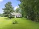 A cozy home featuring a screened porch, mature trees, and a sprawling green lawn at 150 Williamston Ridge Dr, Youngsville, NC 27596