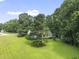 Exterior shot of home surrounded by mature trees and a lush green lawn in a peaceful setting at 150 Williamston Ridge Dr, Youngsville, NC 27596