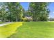 Beautifully landscaped front yard with lush green grass and mature trees providing ample shade at 150 Williamston Ridge Dr, Youngsville, NC 27596