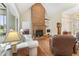 Inviting living room featuring hardwood floors, a brick fireplace, built-in shelving and outdoor views at 150 Williamston Ridge Dr, Youngsville, NC 27596