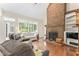 Bright living room features hardwood floors, a brick fireplace, and a large window offering an outdoor view at 150 Williamston Ridge Dr, Youngsville, NC 27596