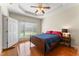 Bedroom featuring hardwood floors, a tray ceiling, and ample natural light at 150 Williamston Ridge Dr, Youngsville, NC 27596