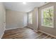 Comfortable bedroom featuring wood-look flooring and sunlit windows with outside views at 1611 Poole Rd, Raleigh, NC 27610