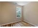 Neutral bedroom featuring wood-look flooring, base molding, and a sunlit window at 1611 Poole Rd, Raleigh, NC 27610