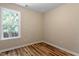 Bedroom with wood-look flooring, a window view, and neutral walls at 1611 Poole Rd, Raleigh, NC 27610