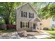 Charming two-story home featuring black shutters, a covered porch, and a meticulously landscaped yard at 1611 Poole Rd, Raleigh, NC 27610