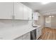 Bright kitchen featuring white cabinets, white countertops, and stainless steel appliances with wood-look flooring at 1611 Poole Rd, Raleigh, NC 27610