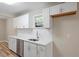 Galley kitchen featuring white cabinets, white subway tile backsplash, and stainless steel appliances at 1611 Poole Rd, Raleigh, NC 27610
