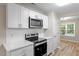 Updated kitchen with white cabinets, stainless steel appliances, white countertops, and modern backsplash at 1611 Poole Rd, Raleigh, NC 27610