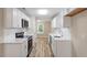Bright kitchen featuring white cabinets, stainless steel appliances, white countertops, and wood-look flooring at 1611 Poole Rd, Raleigh, NC 27610