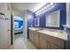Bathroom featuring double vanity sinks with gray cabinets and a glass enclosed shower at 1909 Piperwood Ct, Durham, NC 27713