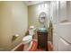 Stylish powder room featuring a unique glass bowl sink, decorative mirror, and wood flooring at 1909 Piperwood Ct, Durham, NC 27713