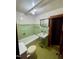 Classic bathroom featuring a green tile accent, vintage fixtures and a mirrored medicine cabinet at 229 Maple Dr, Oxford, NC 27565