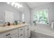 Bathroom featuring double sinks, vanity, soaking tub, and a large window at 2833 Gross Ave, Wake Forest, NC 27587