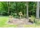 A stone patio with multiple tables surrounded by mature trees, ferns, and native plants at 2849 Rue Sans Famille, Raleigh, NC 27607