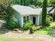 View of the home exterior featuring lush landscaping and gray vinyl siding at 2849 Rue Sans Famille, Raleigh, NC 27607