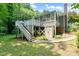 Exterior view of back deck with stairs, enclosed porch, storage and exposed pilings and brick at 2849 Rue Sans Famille, Raleigh, NC 27607