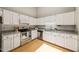 Modern kitchen with stainless steel appliances, white cabinets, tile backsplash, and granite countertops at 2849 Rue Sans Famille, Raleigh, NC 27607