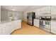 Well-lit kitchen with white cabinets, granite countertops, stainless steel appliances, and wood floors at 2849 Rue Sans Famille, Raleigh, NC 27607