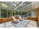 Bright sunroom with glass ceiling and walls, outdoor view and striped rug at 2849 Rue Sans Famille, Raleigh, NC 27607