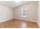 Neutral bedroom showcasing wood floors, a window, and classic trim at 2932 Bramblegate Dr, Mebane, NC 27302