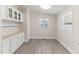 Dining area with serving buffet, overhead cabinets, a window and wood-look vinyl flooring at 2932 Bramblegate Dr, Mebane, NC 27302