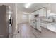 Kitchen with white cabinets, white appliances, neutral countertops and vinyl flooring at 2932 Bramblegate Dr, Mebane, NC 27302