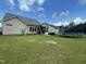 Spacious backyard with green lawn, trampoline, and a screened in patio with covered outdoor furniture at 3 Meadowrue Ln, Youngsville, NC 27596