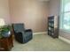 Comfortable sitting area, complete with a bookcase, accent chair, and window with blinds at 3 Meadowrue Ln, Youngsville, NC 27596