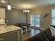 Dining room with access to backyard, featuring wooden table and bench, hardwood floors, and plenty of light at 3 Meadowrue Ln, Youngsville, NC 27596