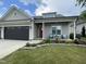 Beautiful home with a red front door, covered porch, and green lawn, showcasing lovely landscaping at 3 Meadowrue Ln, Youngsville, NC 27596