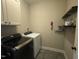 Well-equipped laundry room with modern appliances, overhead cabinets, and a convenient folding shelf at 3 Meadowrue Ln, Youngsville, NC 27596