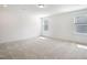 Spacious, empty bedroom with neutral carpet, natural light, and modern ceiling light at , Fuquay Varina, NC 27526