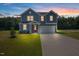 Charming two-story home featuring blue siding, a red door, and an attached two-car garage at , Fuquay Varina, NC 27526
