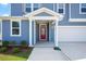 Charming front porch with red front door, manicured landscaping, and attached garage at , Fuquay Varina, NC 27526