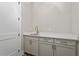 Neutral wet bar with quartz countertop, stylish cabinets, and stainless steel sink at 333 Merrywood Dr, Raleigh, NC 27610