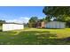 Expansive backyard featuring multiple outbuildings, a propane tank, and a lush green lawn at 3701 Oak Grove Church Rd, Mebane, NC 27302