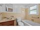 Bathroom features a tub, toilet, sink, and window with natural light at 3701 Oak Grove Church Rd, Mebane, NC 27302