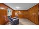 Cozy bedroom features wood paneling, a window letting in natural light, and a comfortable recliner at 3701 Oak Grove Church Rd, Mebane, NC 27302