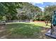 This backyard has a large green lawn, a fence, a swing set, a trampoline, and lots of trees at 3814 Tyler Bluff Ln, Raleigh, NC 27616
