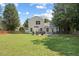 This backyard has a green lawn, a fence, a hot tub, an outdoor dining set, and lots of trees at 3814 Tyler Bluff Ln, Raleigh, NC 27616