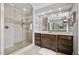 Modern bathroom featuring glass shower, dark wood vanity and light tile floor at 39 Wood Stork Ct, Clayton, NC 27520