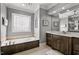 Elegant bathroom features a soaking tub with decorative leaded glass window at 39 Wood Stork Ct, Clayton, NC 27520