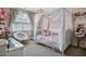 Charming bedroom with a canopy bed, pink walls, and lots of natural light at 39 Wood Stork Ct, Clayton, NC 27520