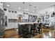 Well-lit kitchen with island seating and stainless appliances, adjacent to the dining area and stairs at 39 Wood Stork Ct, Clayton, NC 27520