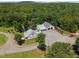 Aerial view showcasing a charming home, spacious garage, and lush greenery on a sprawling estate at 4050 Culbreth Rd, Stem, NC 27581