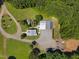 Aerial view of a well-maintained property with a home, garages, and manicured grounds surrounded by mature trees at 4050 Culbreth Rd, Stem, NC 27581